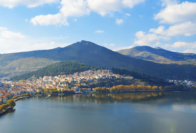 Scenic view of lake by townscape against sky