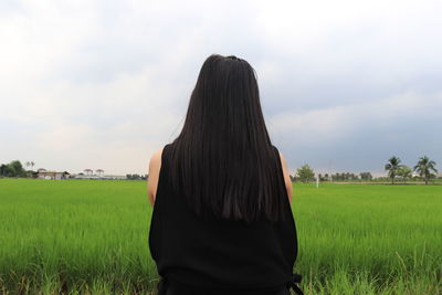 Rear view of woman on agricultural field