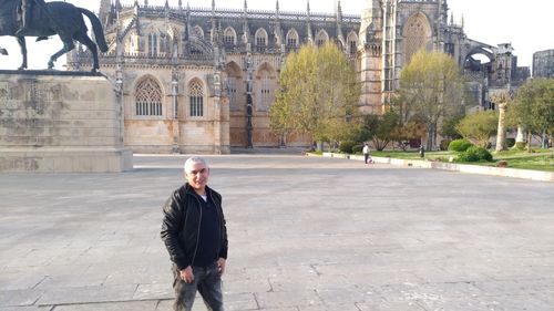 Full length of man standing against historic city