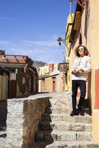 Full length of woman standing against building