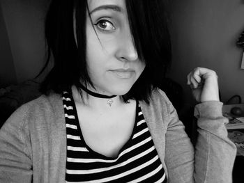 Close-up portrait of smiling young woman at home