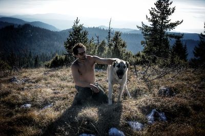 Woman with dog standing on mountain