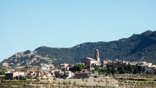 Houses and buildings against clear blue sky