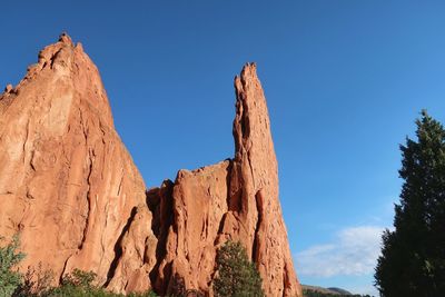 Low angle view of rock formations against blue sky