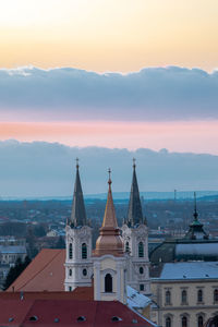 Buildings in city against sky during sunset