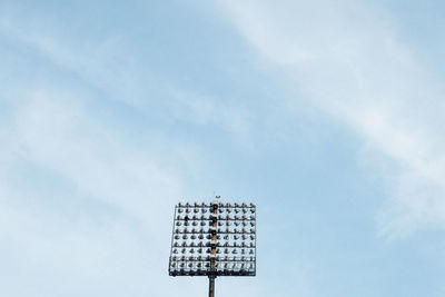 Stadium lighting mast against blue sky