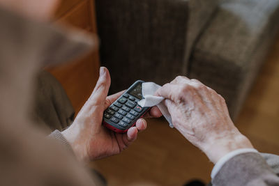 Midsection of man holding mobile phone