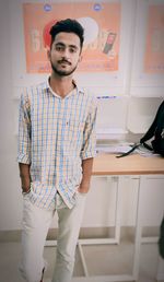 Portrait of young man standing at home