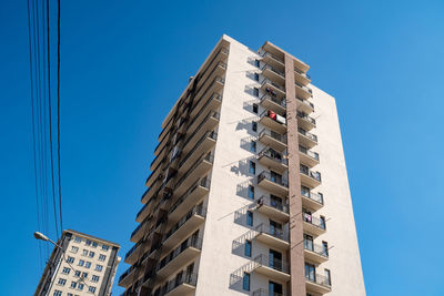 Low angle view of buildings against clear blue sky