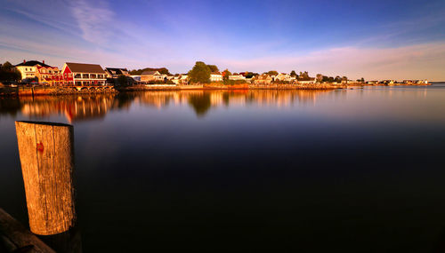 Scenic view of lake by buildings against sky