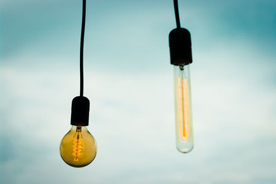 A pair of lightbulbs against the sky.