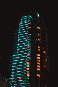 Low angle view of illuminated buildings against sky at night