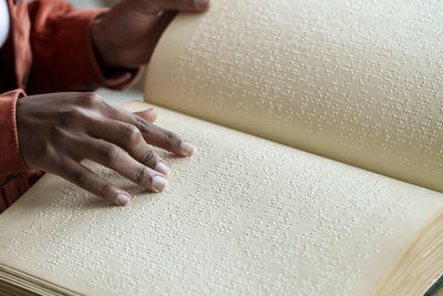 Hands of woman reading braille text