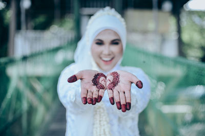 Portrait of beautiful woman standing against blurred background