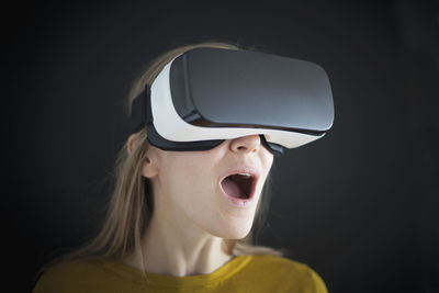 Astonished woman wearing virtual reality glasses