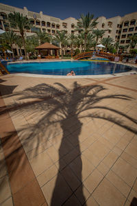 Shadow of man on swimming pool in city