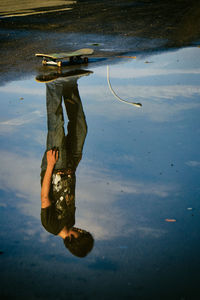 Reflection of man on puddle