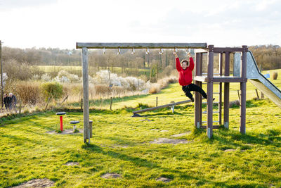 Boy climbing on playgroung on the spring day