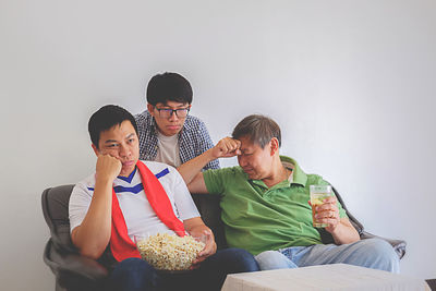 Sad friends watching soccer match at home