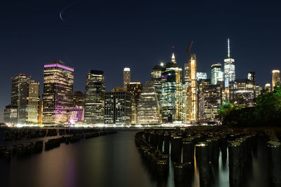 Illuminated buildings against sky at night