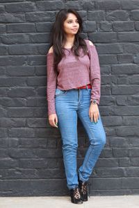 Portrait of young woman standing against brick wall