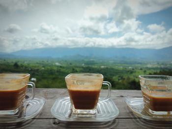 Coffee cup on table against sky