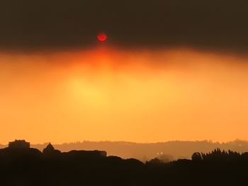 Scenic view of silhouette trees against orange sky