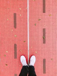 Low section of man standing on red brick wall