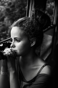 Young woman looking through window while sitting in train