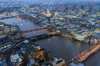 Aerial of bridges over river in illuminated city