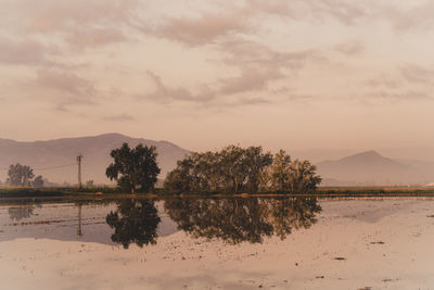 Scenic view of lake against sky at sunset