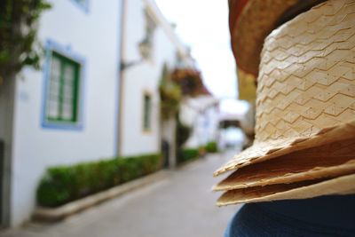 Close-up of hats by road and buildings