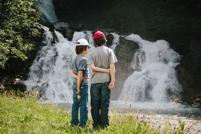 Rear view of boys waterfall in stream