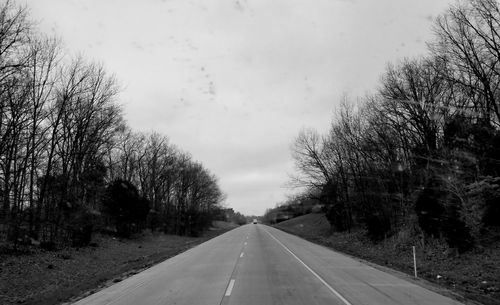 Road amidst trees against sky