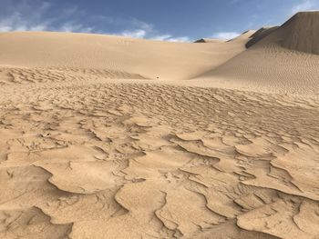 Sand dunes in desert against sky