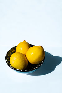 Close-up of oranges in plate on white background