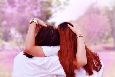 Rear view of two friends sitting outdoors