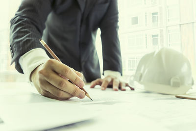 Midsection of man working on table