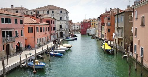 Boats in canal amidst buildings in city