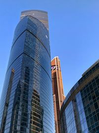 Low angle view of modern buildings against blue sky