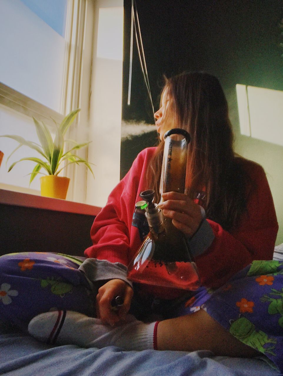 YOUNG WOMAN DRINKING GLASS SITTING AT HOME