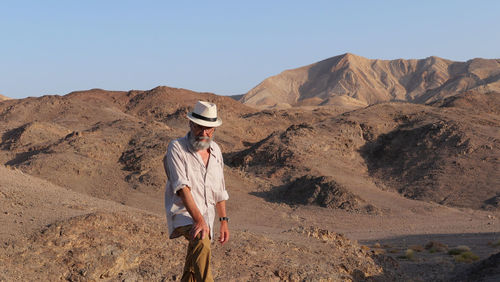 Senior man standing on mountain in the desert 
