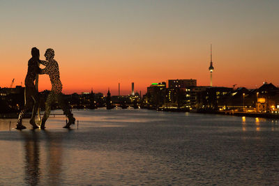 View of city at waterfront during sunset