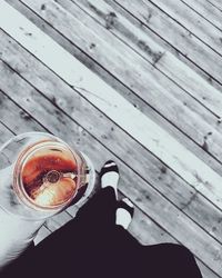 High angle view of hand holding drink on table