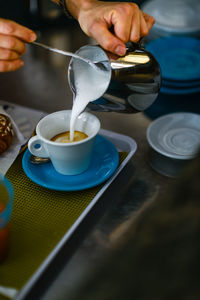 Hands of young adult caucasian female barista at work preparing