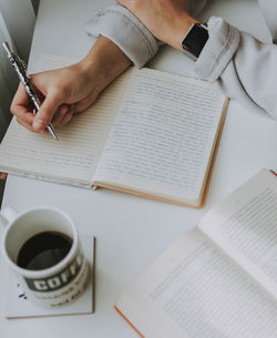 Midsection of man reading book on table