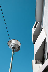 Low angle view of street light against blue sky