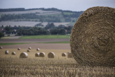 Hay bales on field against sky