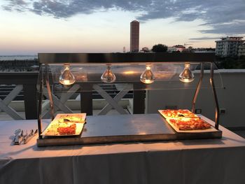Food on table at restaurant against sky during sunset