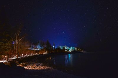 River amidst illuminated city against sky at night